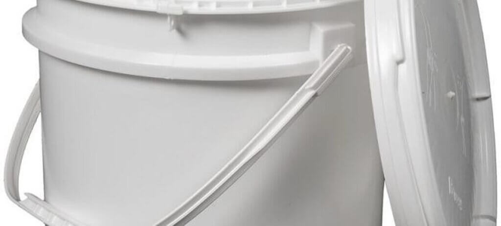 A large white plastic bucket with a lid slightly ajar. It has a sturdy handle and a smooth surface. The bucket is set against a plain white background.